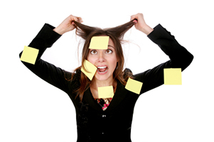 Image of a woman pulling at her hair, she's covered with Post-It notes